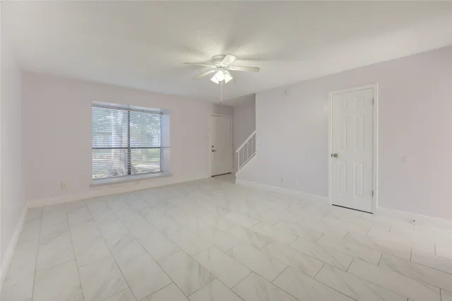 a view of a livingroom with a ceiling fan and window