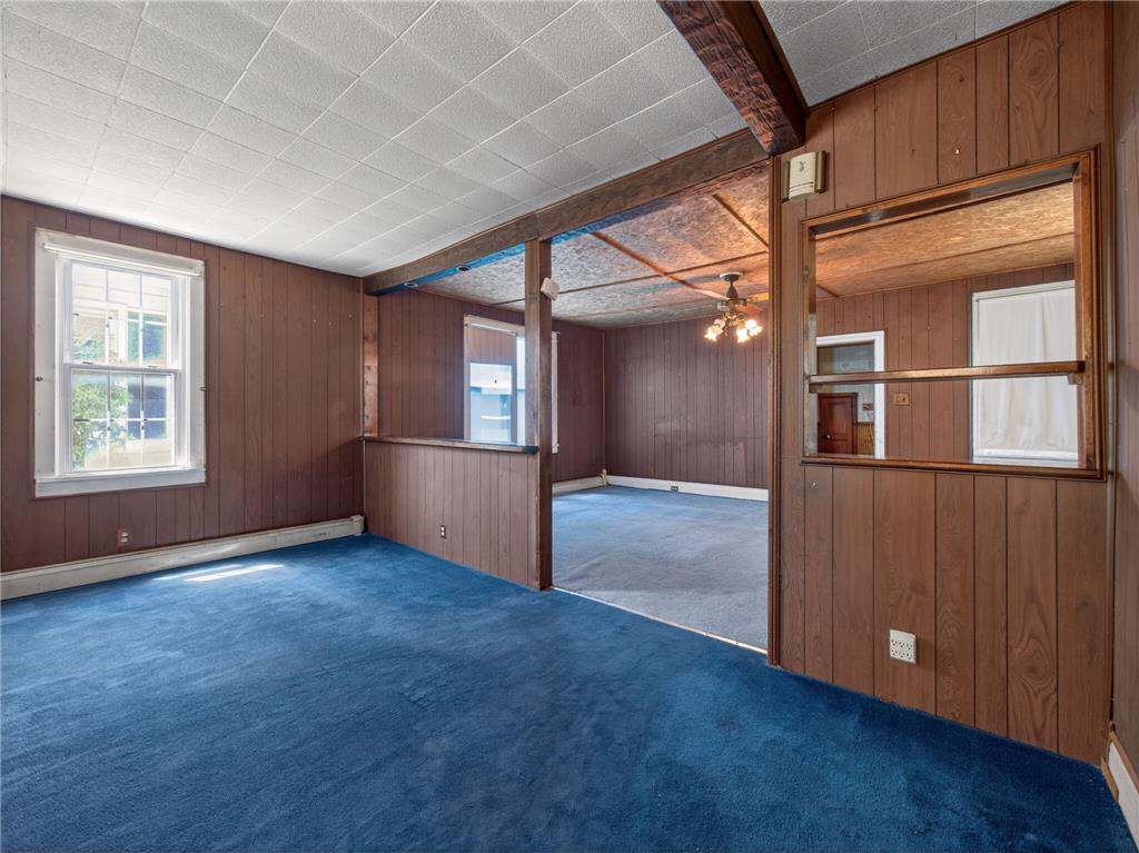 15845 Kutztown Road Mertztown, PA 19539 - Photo 5 of 24 A split-level layout with a blue carpeted floor and wood paneled walls offers a unique vintage appeal.