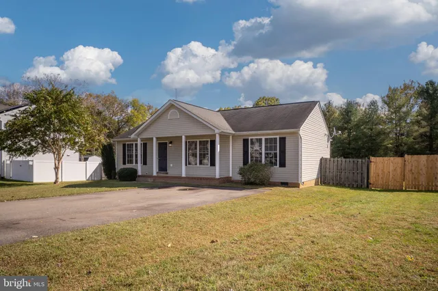 a front view of house with yard and trees in the background