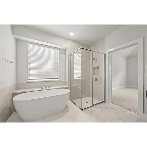a bathroom with a tub sink shower and a mirror