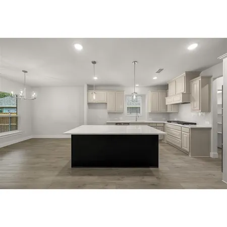 a kitchen with granite countertop a sink stove and cabinets