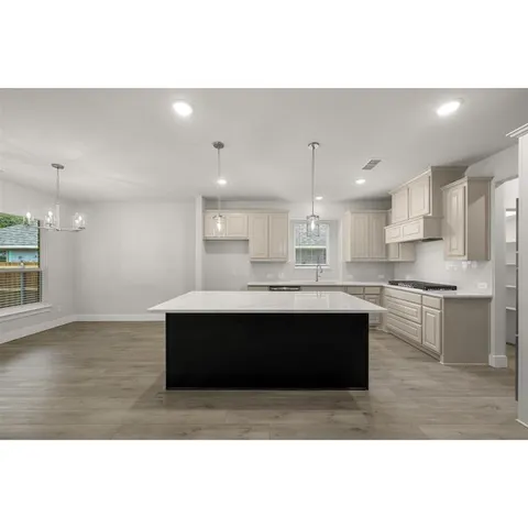 a kitchen with granite countertop a sink stove and cabinets