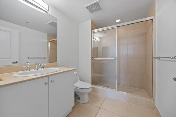 a bathroom with a shower sink vanity mirror and toilet