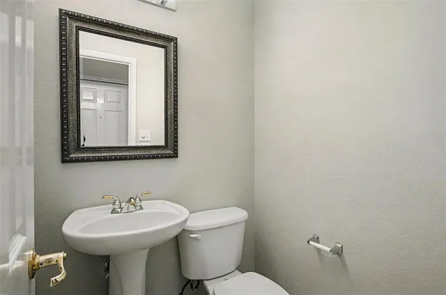 a bathroom with a toilet sink and mirror