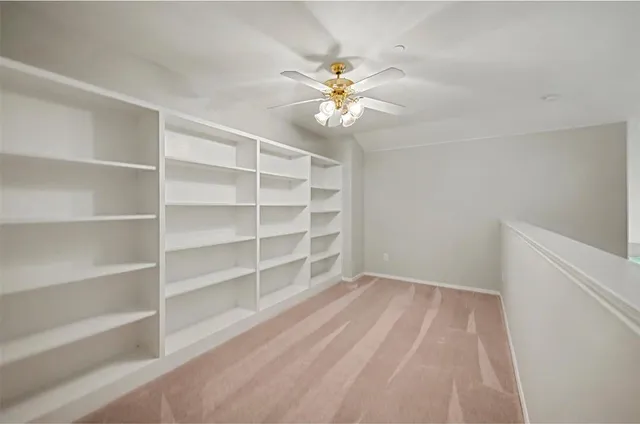 a view of an empty room with a window and a ceiling fan
