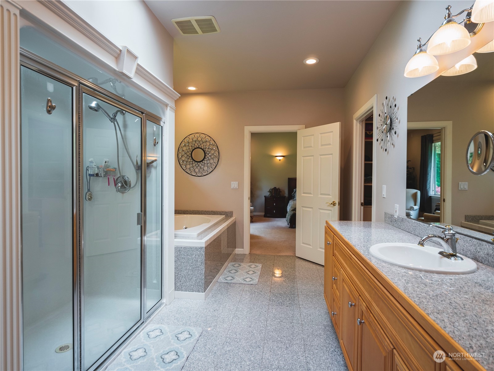 7801 Westlund Road Arlington, WA 98223 - Photo 12 of 39 a bathroom with a granite countertop sink a mirror a bathtub and shower