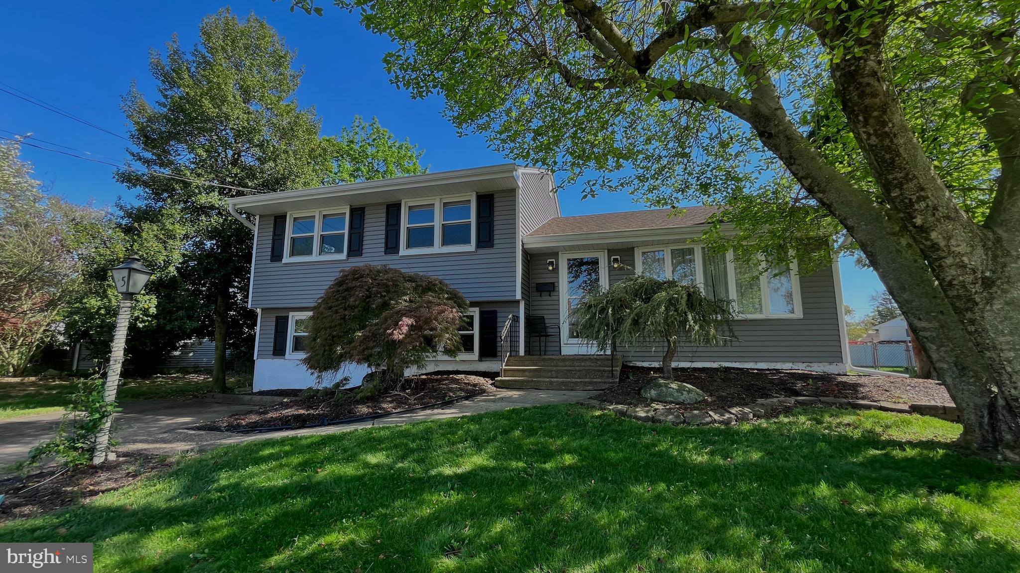 a view of a house with backyard and a tree