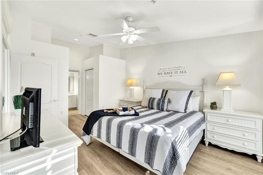 3715 Buttonwood Way, Unit 1722 Naples, FL 34112 - Photo 11 of 29 a bedroom with bed and a chandelier