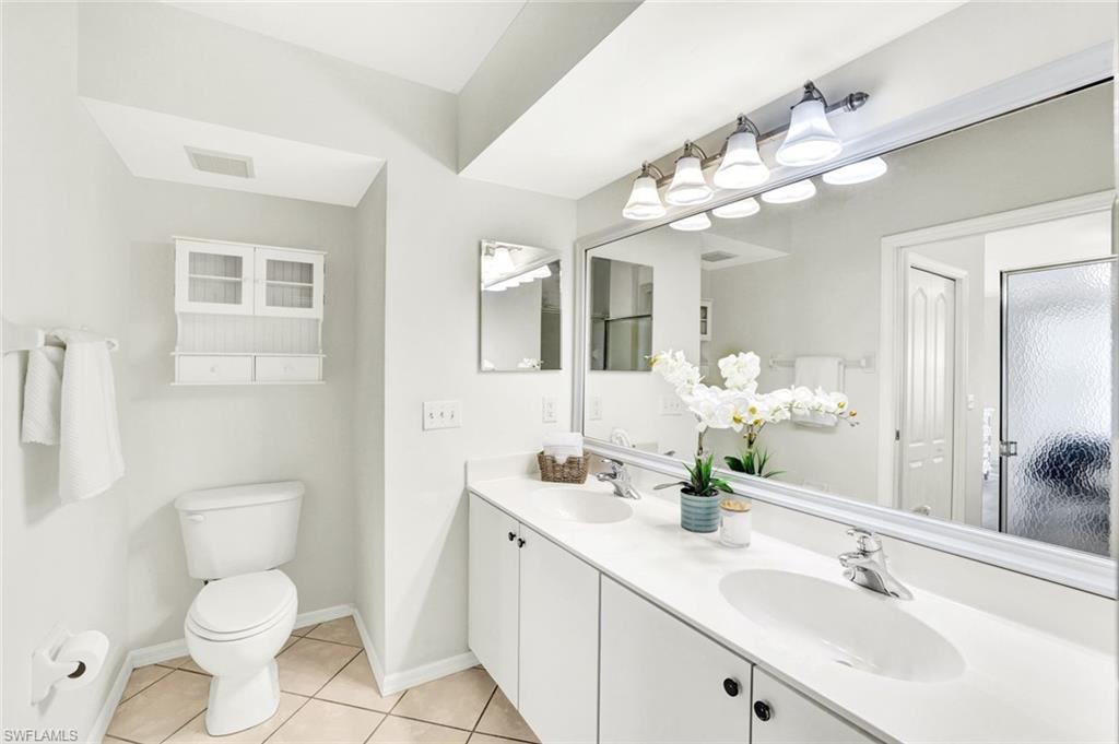 3715 Buttonwood Way, Unit 1722 Naples, FL 34112 - Photo 13 of 29 a bathroom with a toilet sink and mirror