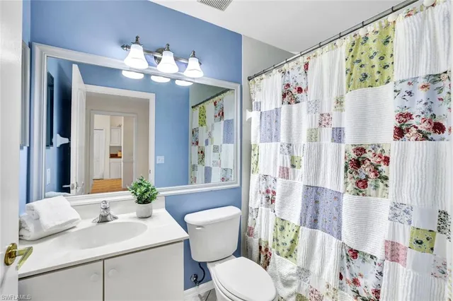 a bathroom with a sink vanity mirror and toilet
