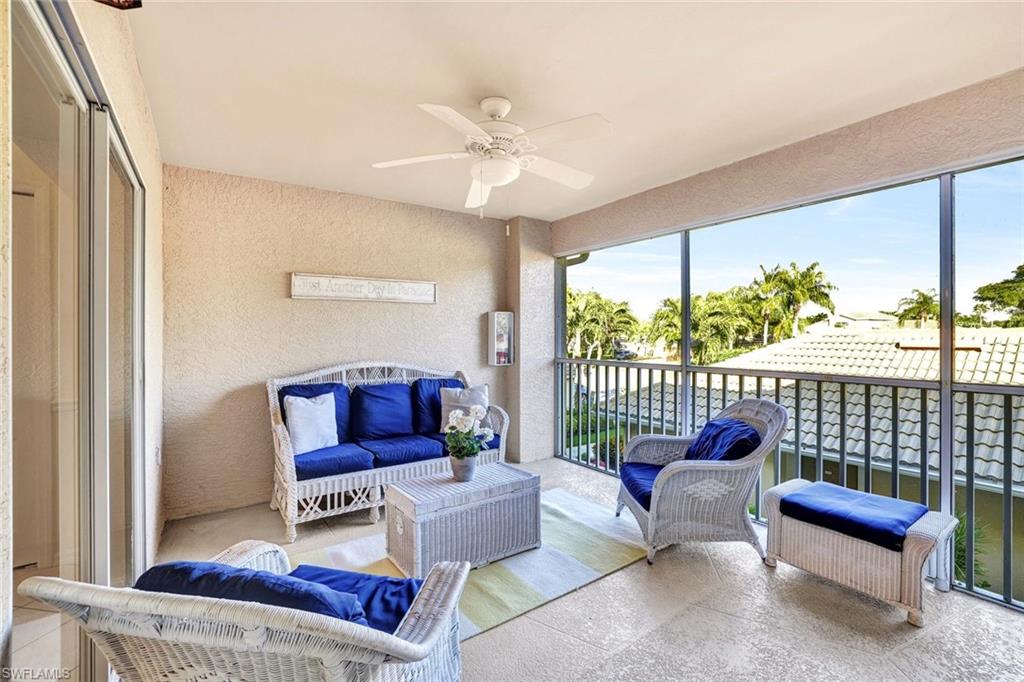 3715 Buttonwood Way, Unit 1722 Naples, FL 34112 - Photo 19 of 29 a living room with furniture and a floor to ceiling window