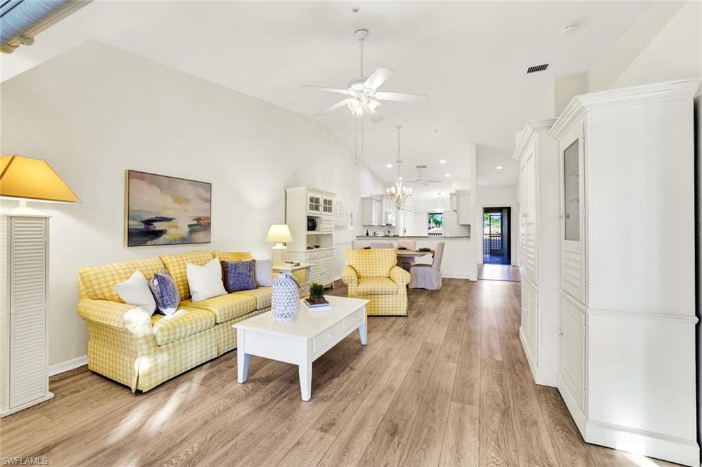 3715 Buttonwood Way, Unit 1722 Naples, FL 34112 - Photo 5 of 29 a living room with fireplace furniture and a wooden floor