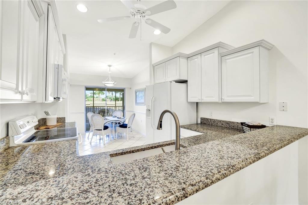 3715 Buttonwood Way, Unit 1722 Naples, FL 34112 - Photo 6 of 29 a kitchen with granite countertop a sink a stove and cabinets