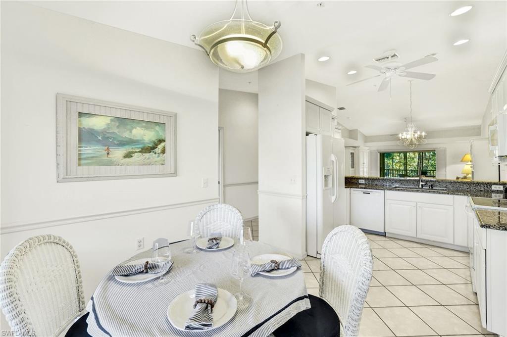 3715 Buttonwood Way, Unit 1722 Naples, FL 34112 - Photo 9 of 29 a kitchen with stainless steel appliances granite countertop a dining table and chairs