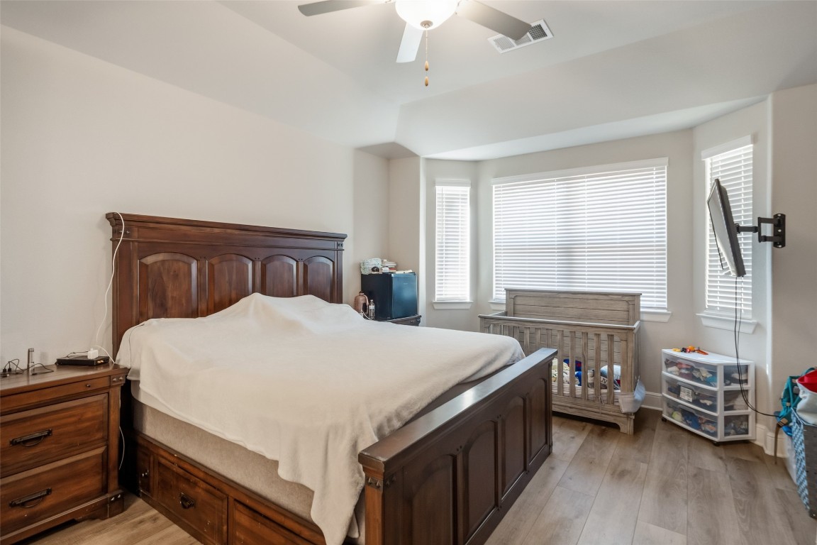 27479 Vivace Drive Spring, TX 77386 - Photo 12 of 25 a bedroom with a bed and a wooden floor