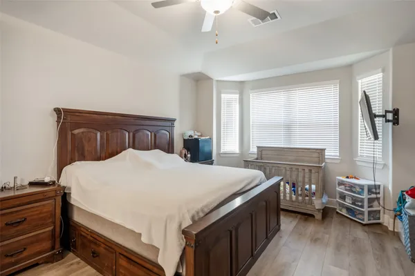 a bedroom with a bed and a wooden floor