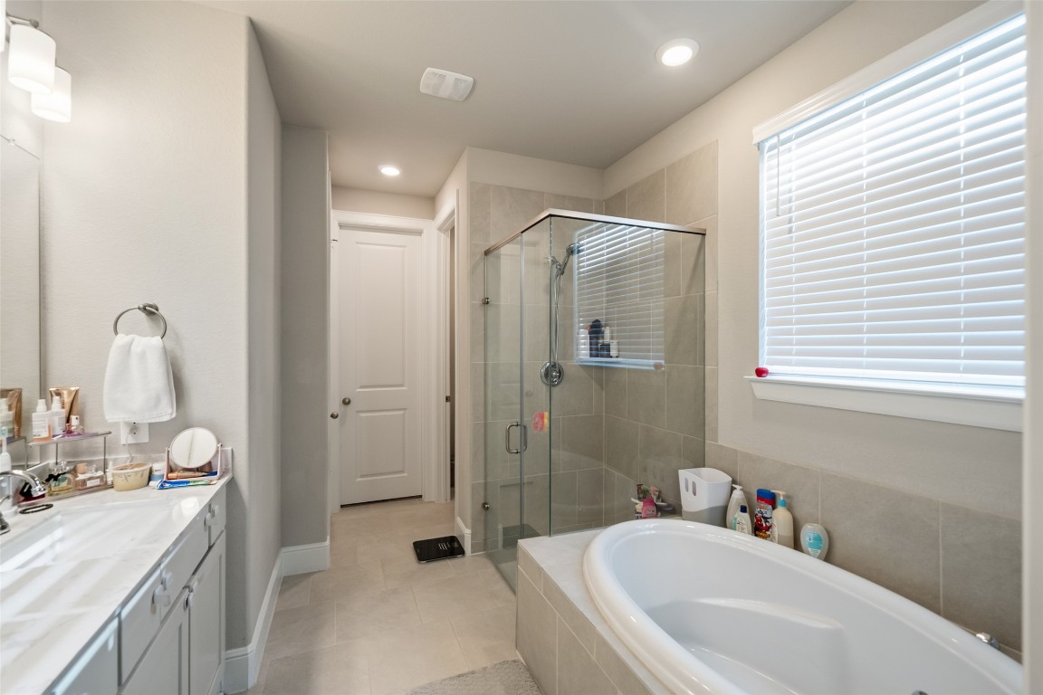 27479 Vivace Drive Spring, TX 77386 - Photo 13 of 25 a bathroom with a tub sink toilet and a window