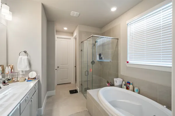a bathroom with a tub sink toilet and a window
