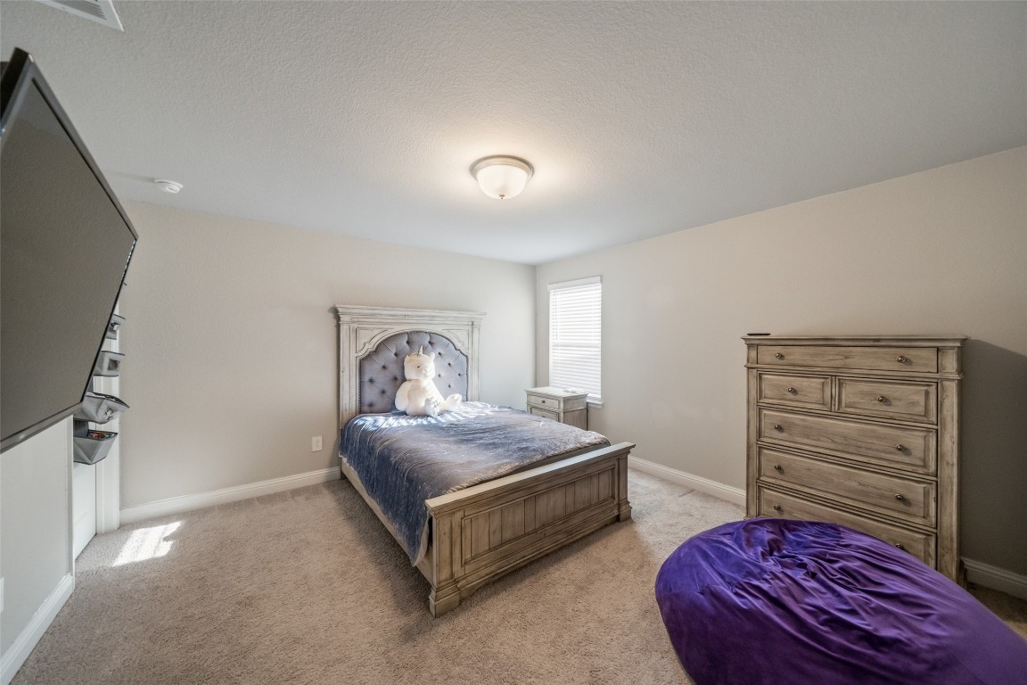 27479 Vivace Drive Spring, TX 77386 - Photo 19 of 25 a bedroom with a bed and a dresser