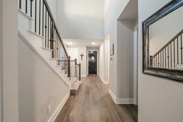 a view of staircase with wooden floor and white walls