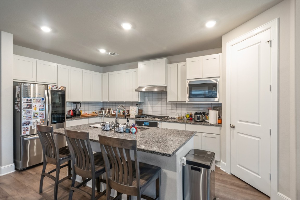 27479 Vivace Drive Spring, TX 77386 - Photo 6 of 25 a kitchen with stainless steel appliances granite countertop a refrigerator a stove top oven a sink dishwasher and a refrigerator with wooden floor