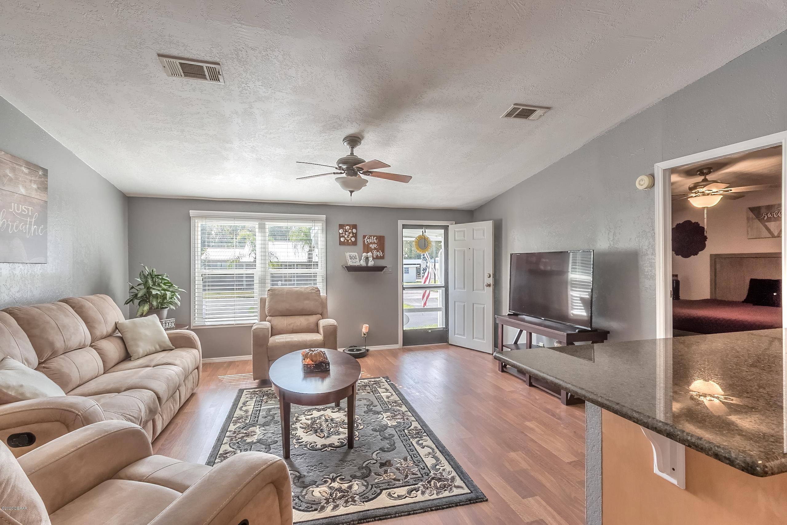 24513 Snail Road Astor, FL 32102 - Photo 11 of 40 a living room with furniture and a flat screen tv