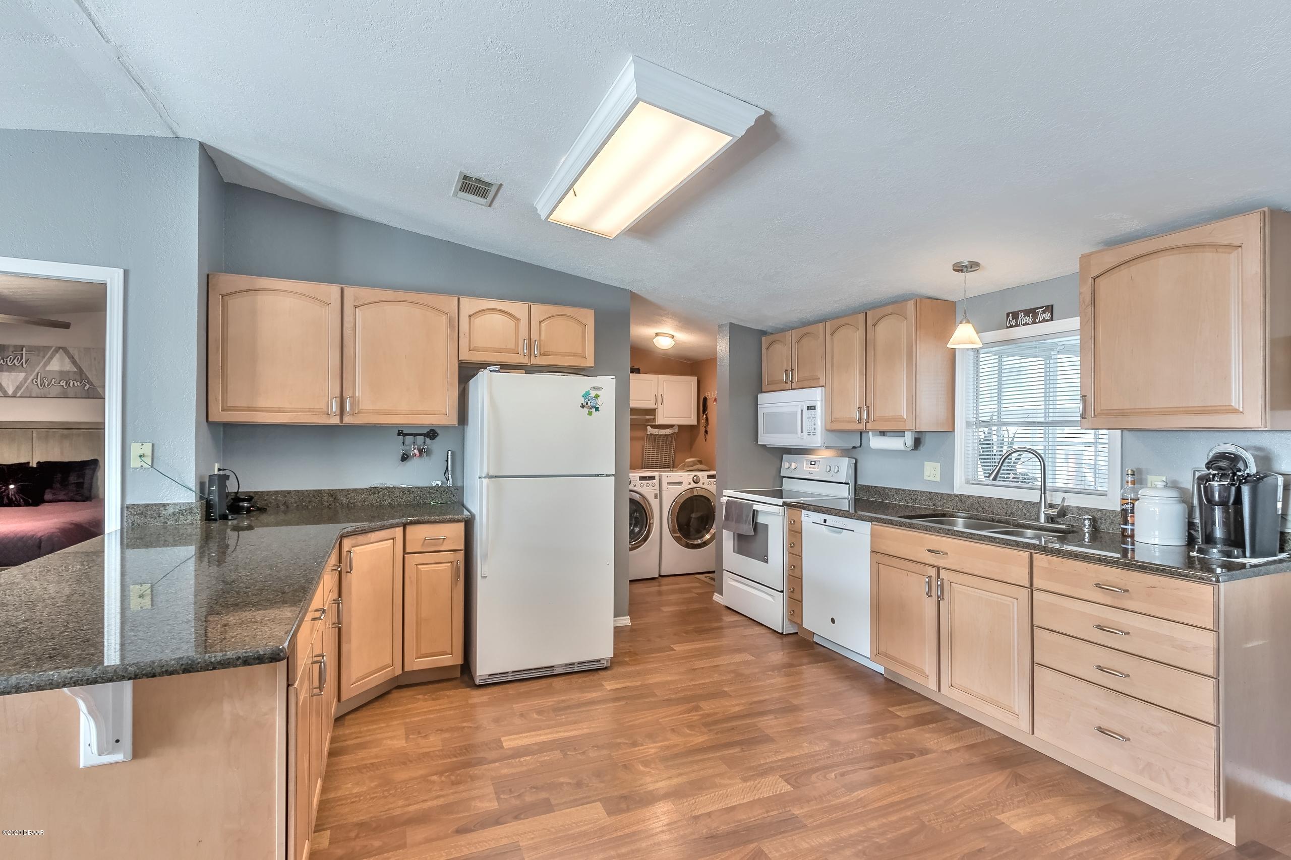 24513 Snail Road Astor, FL 32102 - Photo 12 of 40 a kitchen with refrigerator cabinets and a sink