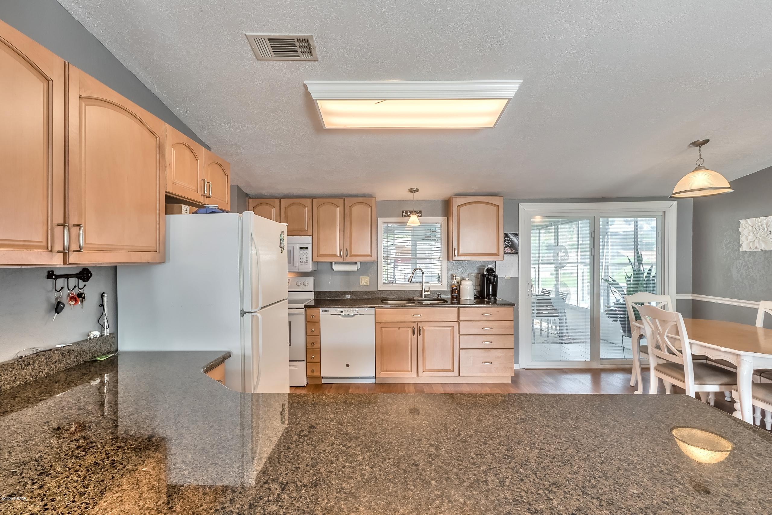 24513 Snail Road Astor, FL 32102 - Photo 13 of 40 a kitchen with refrigerator and cabinets