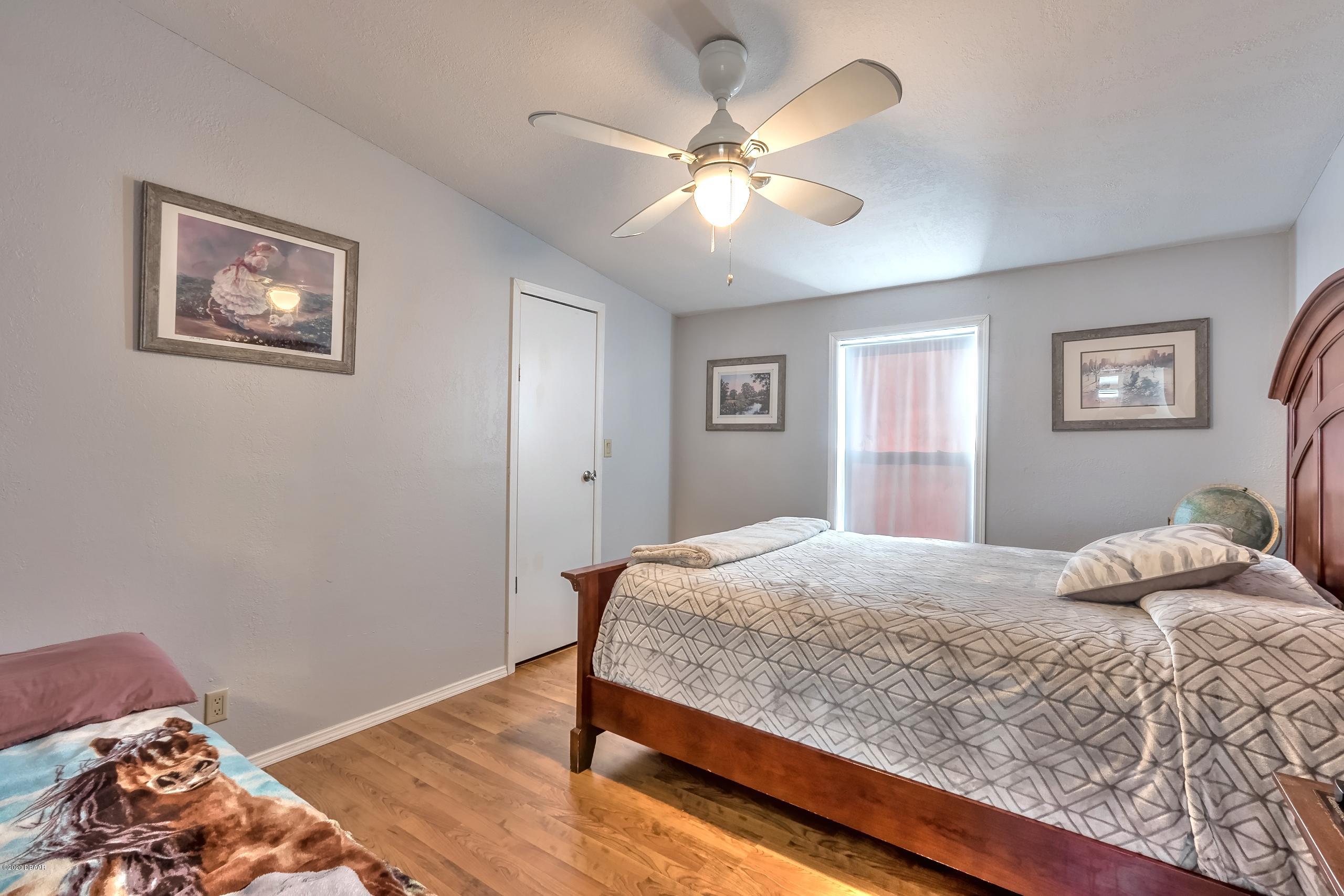 24513 Snail Road Astor, FL 32102 - Photo 18 of 40 a bedroom with a bed and a chandelier