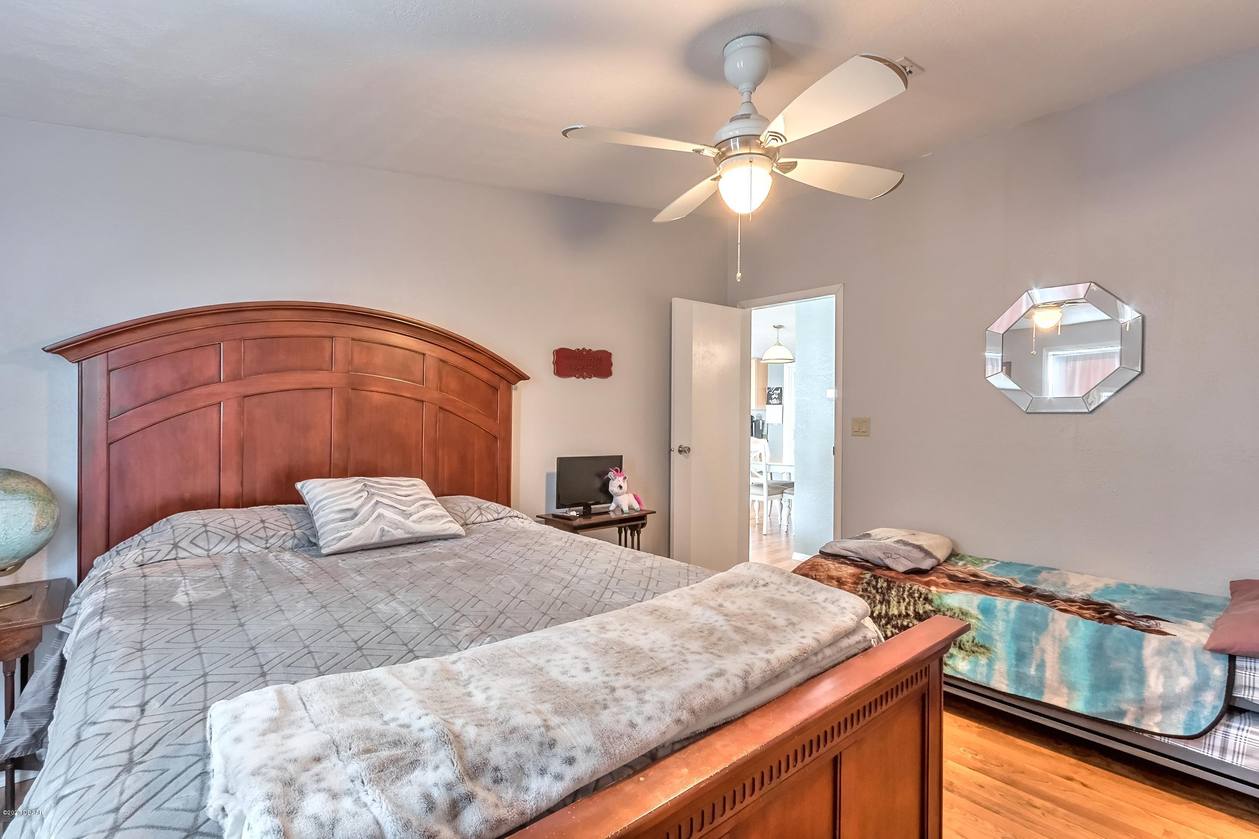 24513 Snail Road Astor, FL 32102 - Photo 19 of 40 a bedroom with a bed and a chandelier