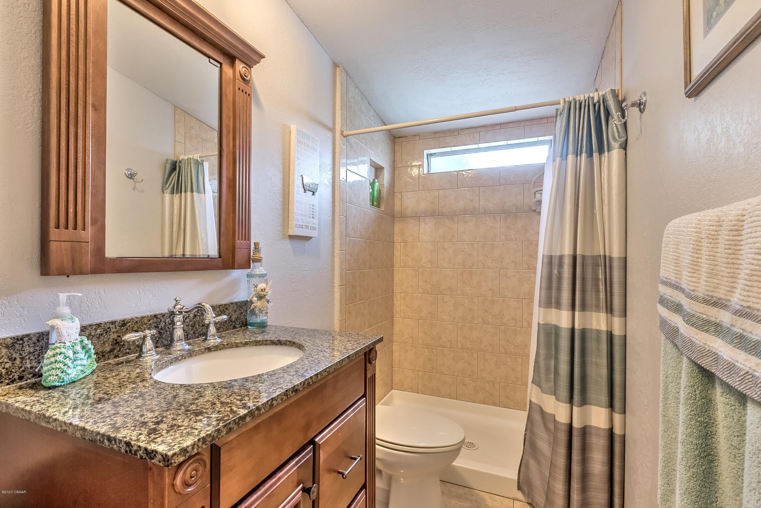 24513 Snail Road Astor, FL 32102 - Photo 20 of 40 a bathroom with a granite countertop sink and a mirror