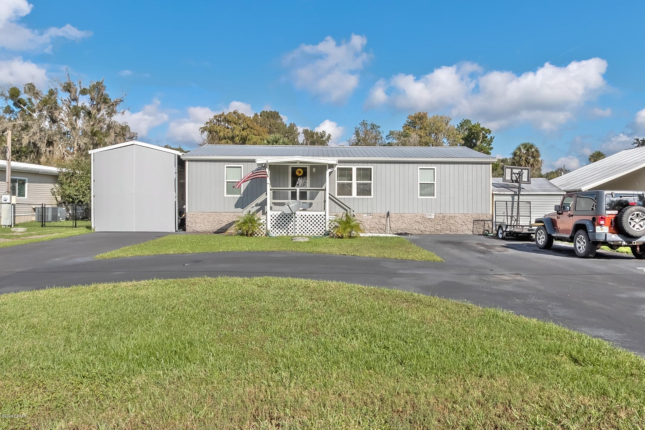 24513 Snail Road Astor, FL 32102 - Photo 2 of 40 a house with garden in front of it