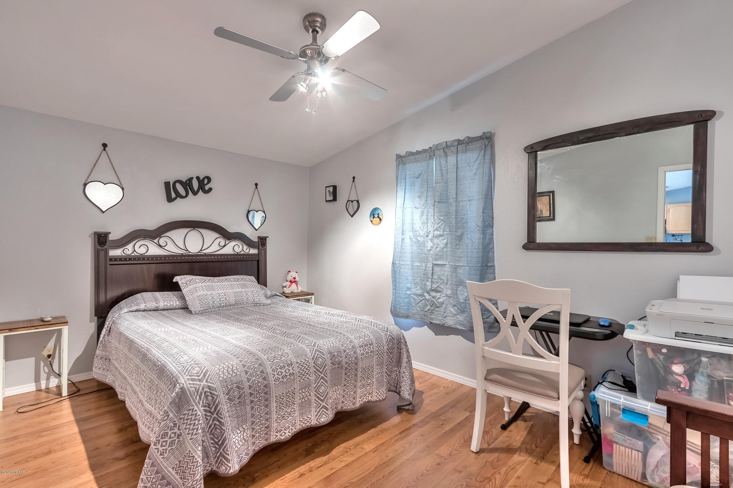 24513 Snail Road Astor, FL 32102 - Photo 21 of 40 a bedroom with a bed a table and chair
