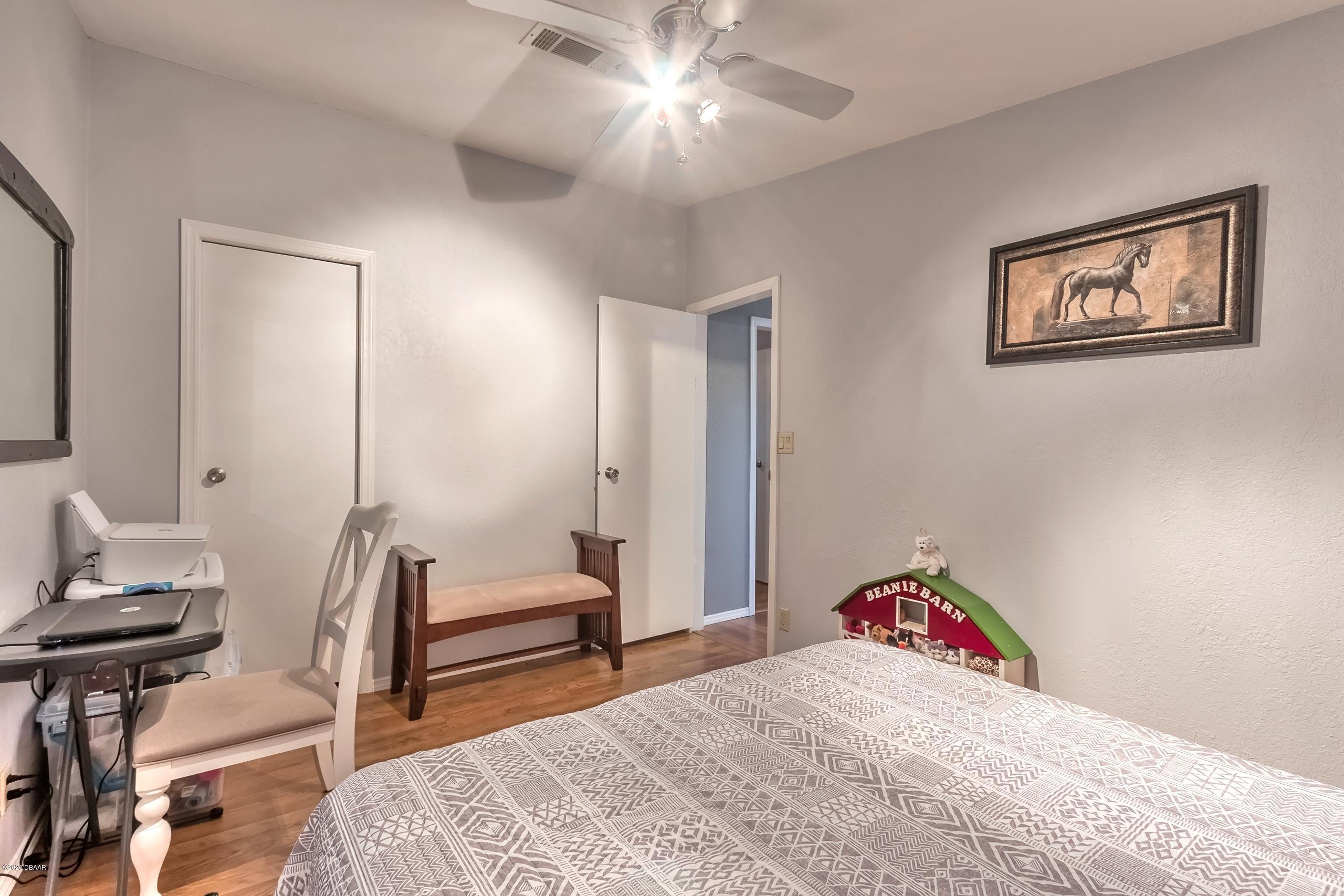 24513 Snail Road Astor, FL 32102 - Photo 22 of 40 a bedroom with a bed and a chandelier