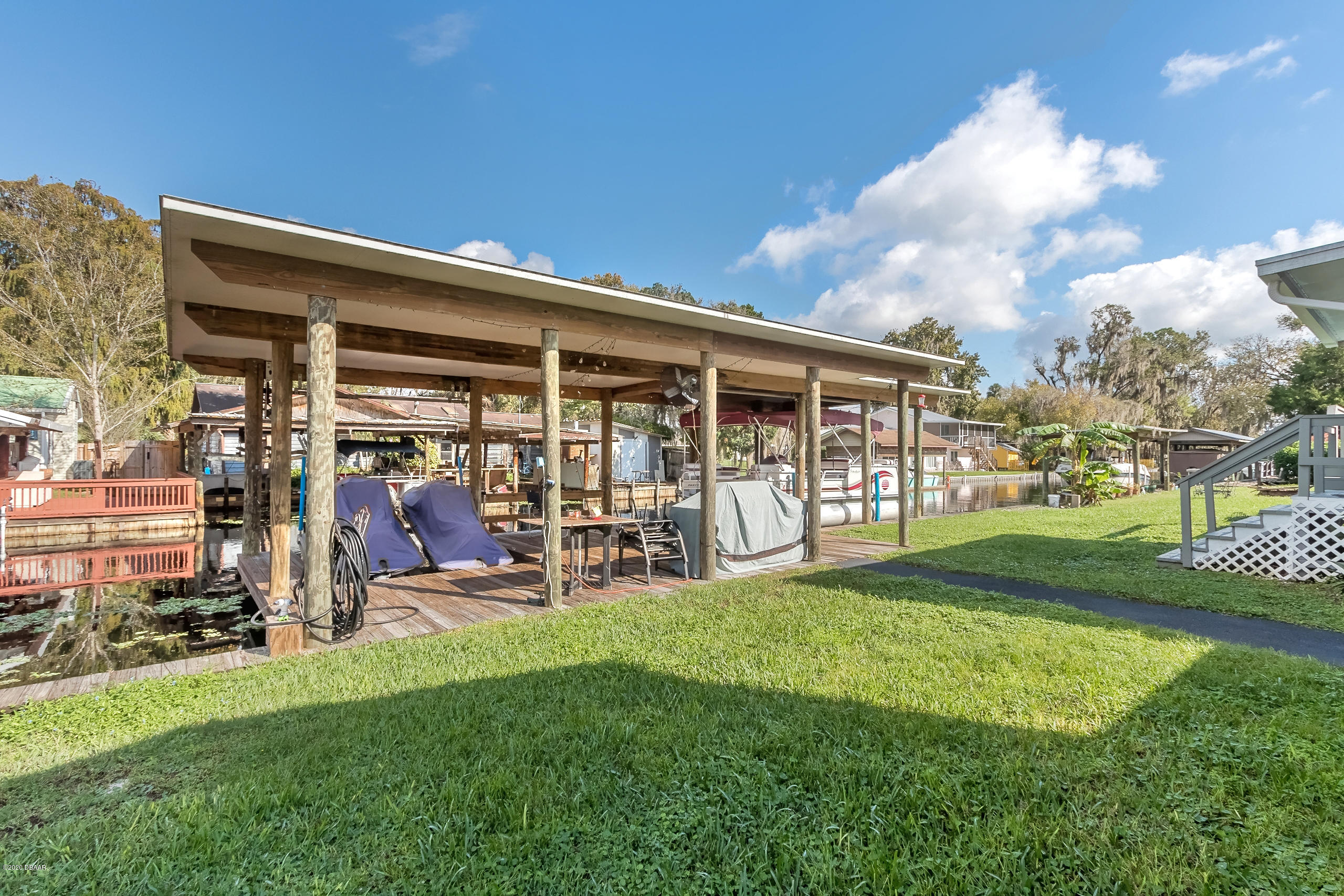 24513 Snail Road Astor, FL 32102 - Photo 26 of 40 a view of a porch with chairs and backyard