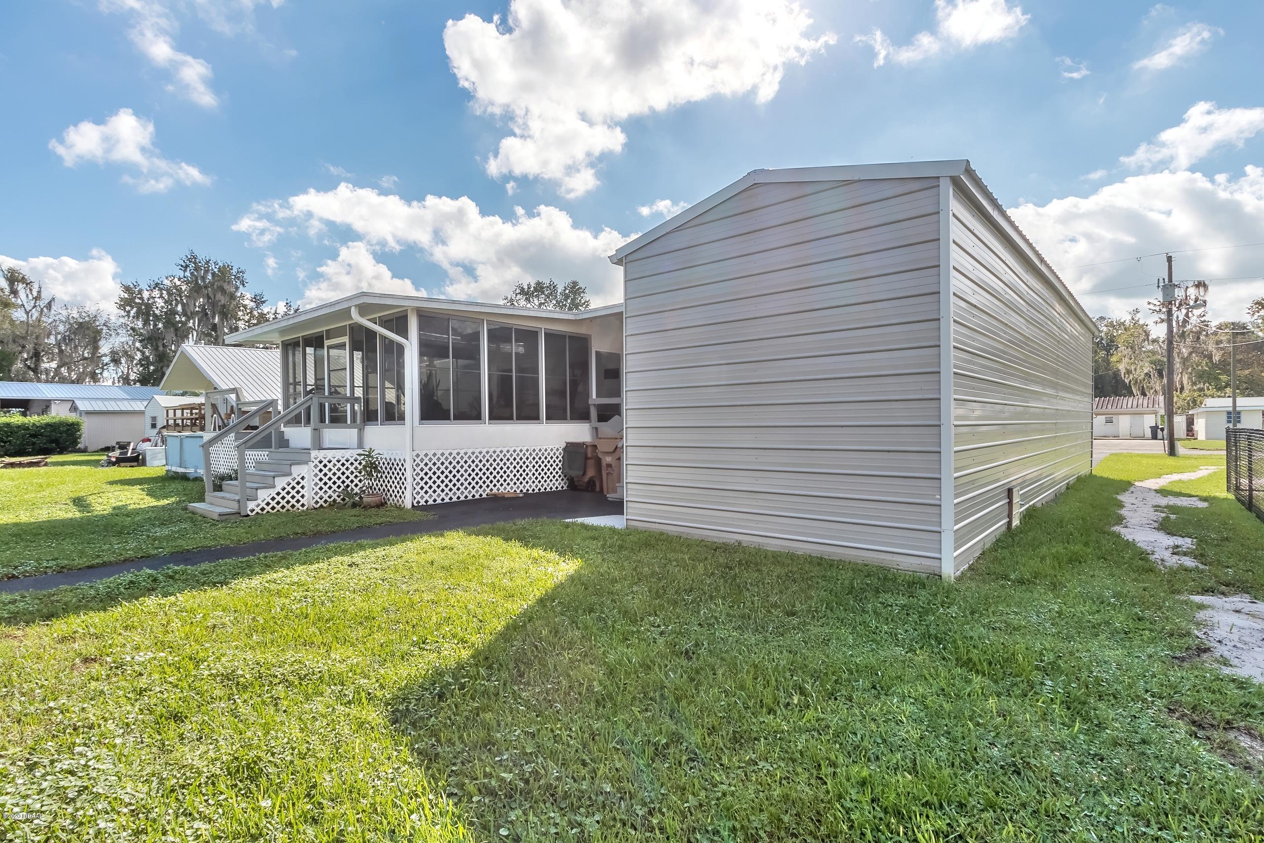24513 Snail Road Astor, FL 32102 - Photo 27 of 40 a view of a house with backyard and sitting area