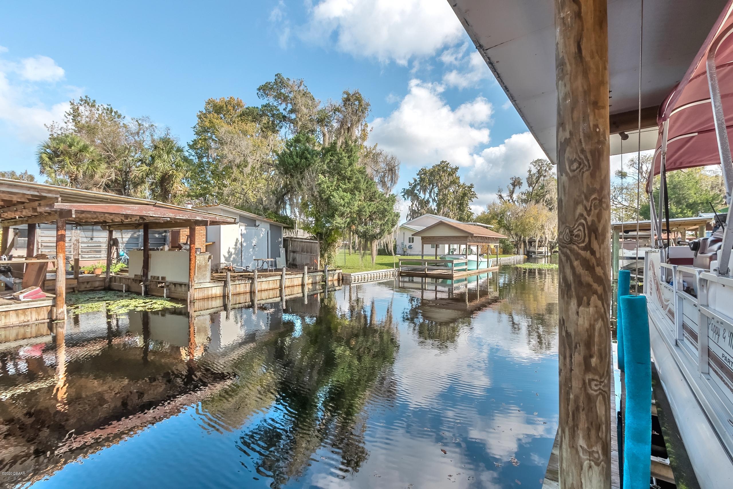 24513 Snail Road Astor, FL 32102 - Photo 33 of 40 a view of swimming pool with outdoor seating and lake view