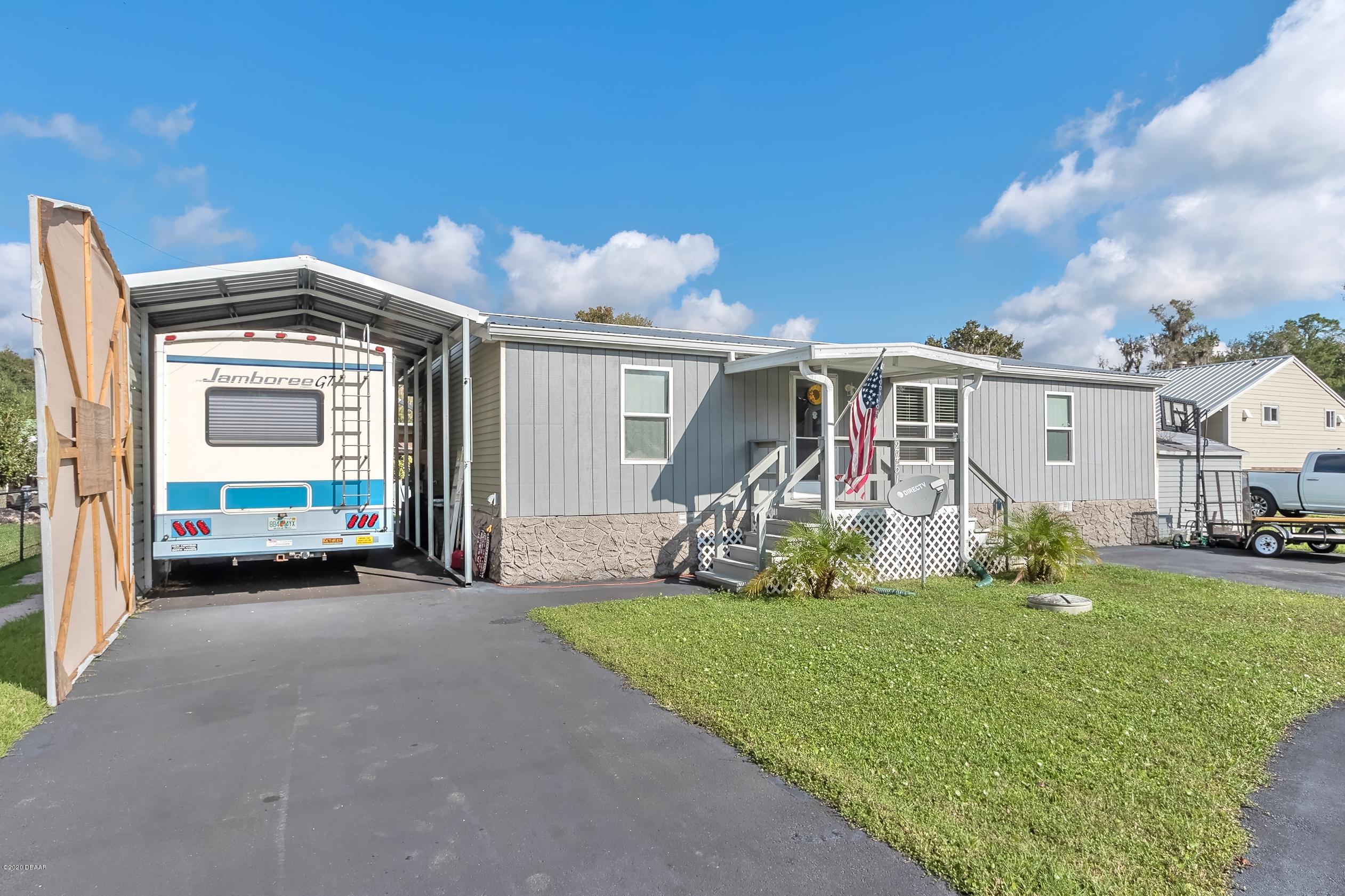 24513 Snail Road Astor, FL 32102 - Photo 4 of 40 a view of a house with a yard and garage