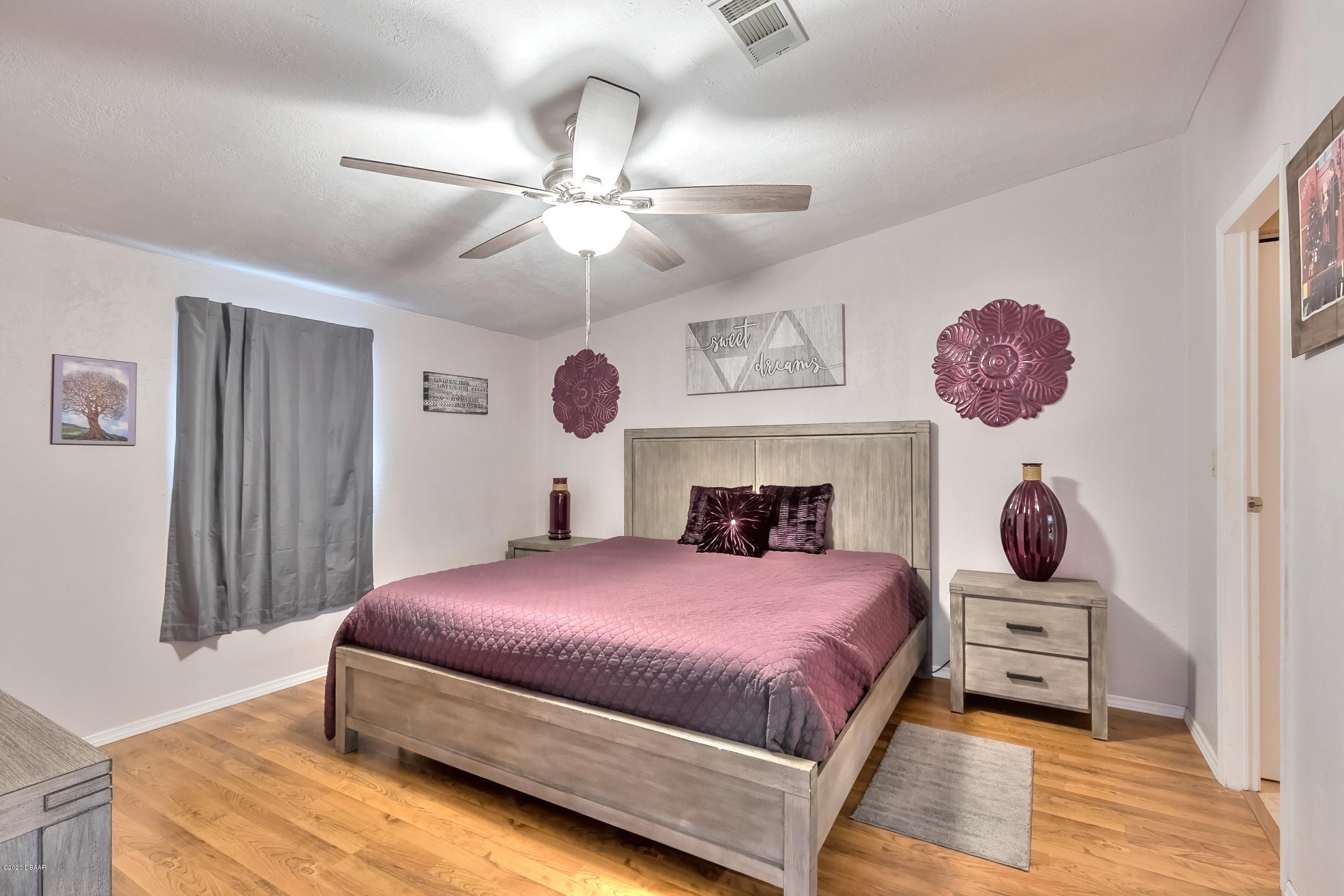 24513 Snail Road Astor, FL 32102 - Photo 5 of 40 a bedroom with a bed and a chandelier