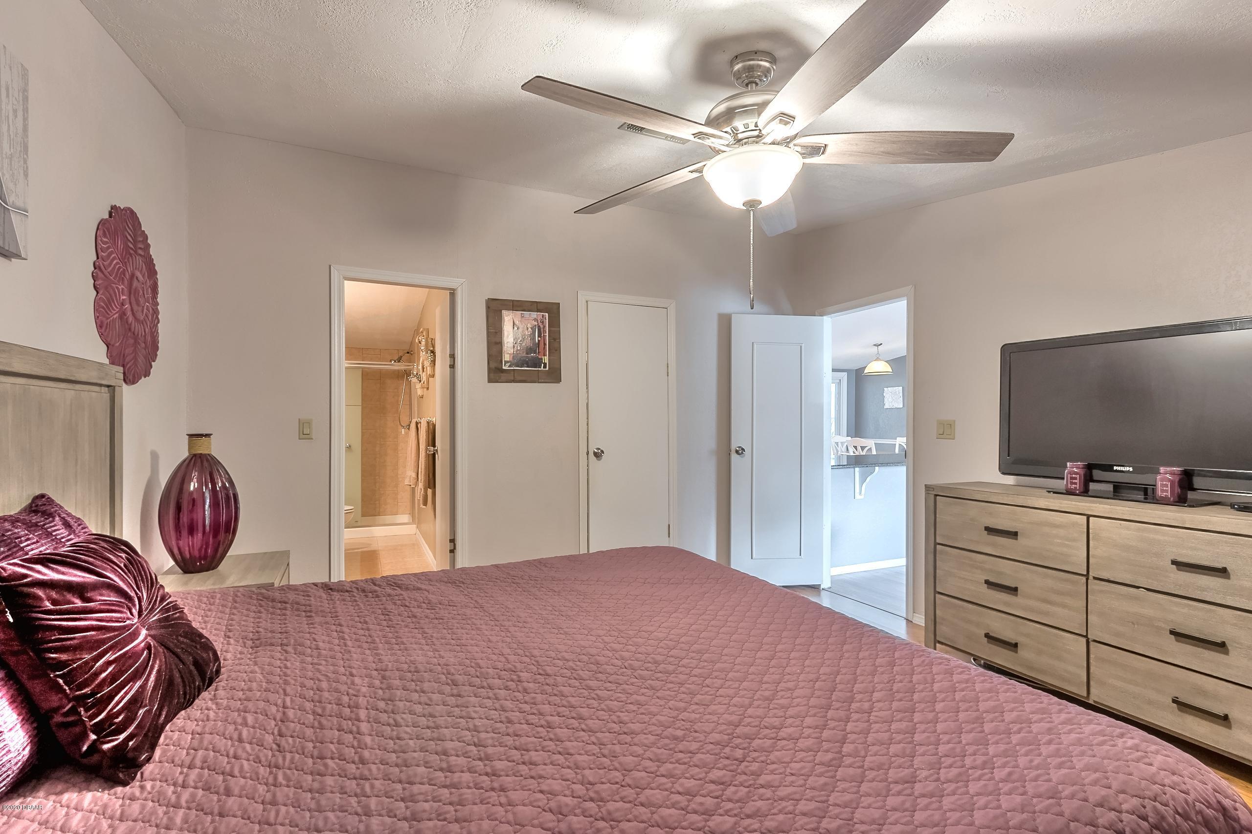24513 Snail Road Astor, FL 32102 - Photo 6 of 40 a bedroom with a bed and a chandelier