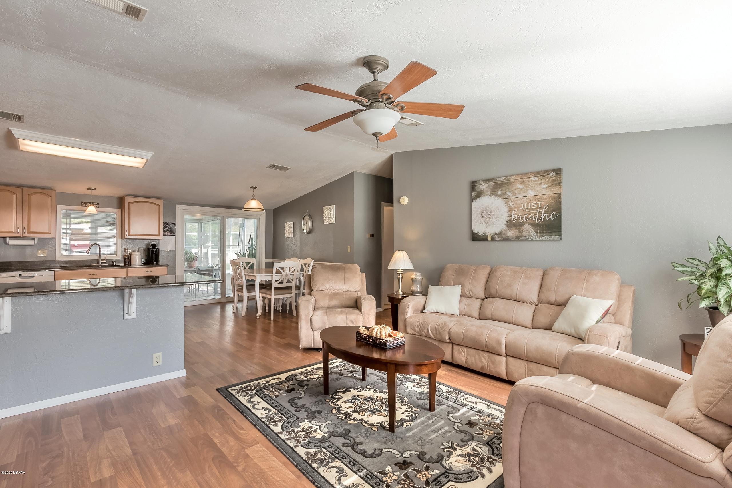 24513 Snail Road Astor, FL 32102 - Photo 9 of 40 a living room with furniture kitchen view and a chandelier