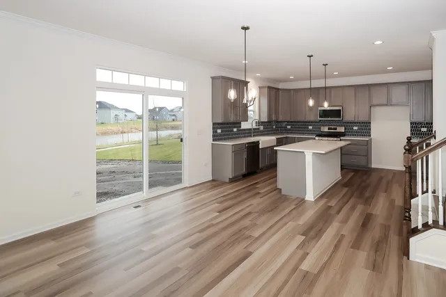 a large kitchen with kitchen island a large counter space a sink appliances and cabinets