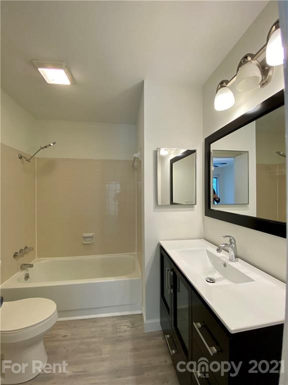 1604 Sharon Road West Charlotte, NC 28210 - Photo 10 of 15 a bathroom with a double vanity sink a toilet a mirror and shower