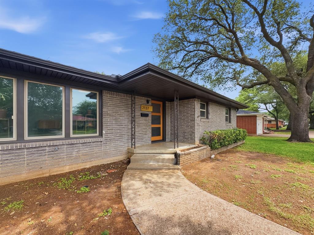 Contemporary brick facade with large picture windows and a prominent front entry