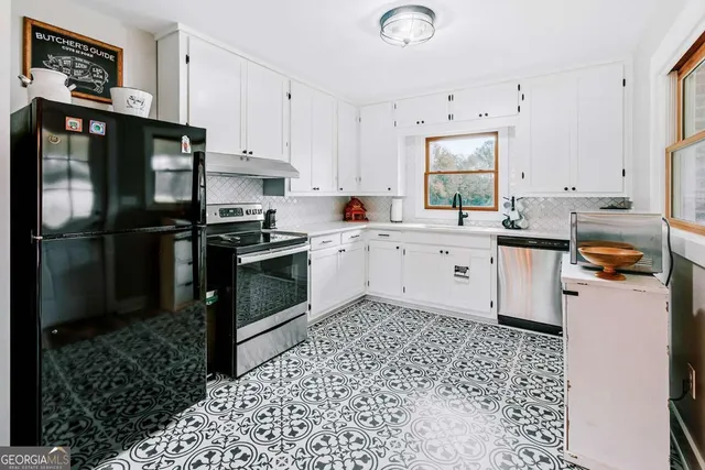 a kitchen with a refrigerator a stove a sink dishwasher and wooden cabinets