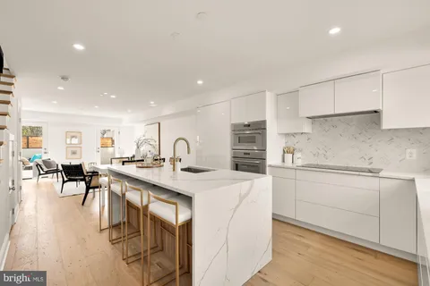 a kitchen with white cabinets and sink
