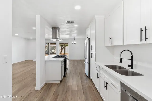 a kitchen with stainless steel appliances granite countertop a stove a sink and a refrigerator