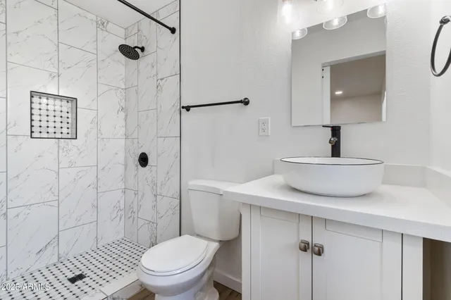 a view of an empty room with wooden floor and a ceiling fan