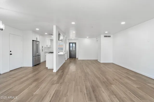 a view of a kitchen with wooden floor and a refrigerator