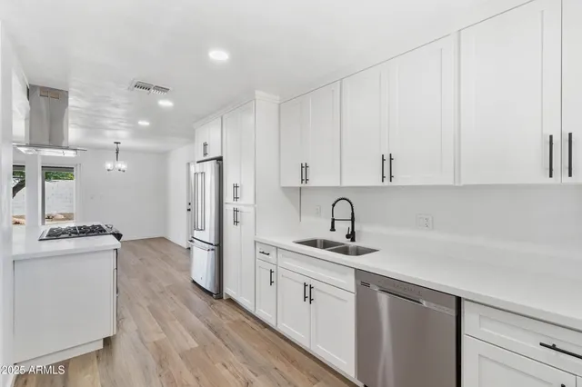 a kitchen with stainless steel appliances granite countertop a refrigerator and a stove top oven
